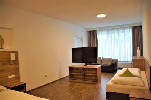 a living room with a flat screen tv and a couch at Maiers Hotel Parsberg in Parsberg