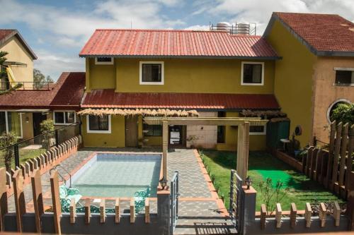 ein Haus mit einem Swimmingpool davor in der Unterkunft Stone shelter in Mahabaleshwar