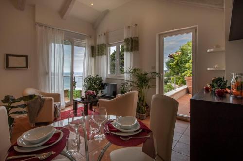uma cozinha e sala de jantar com mesa e cadeiras em Luxury Beachfront Villa Dubrovnik Palace with private pool and jacuzzi by the beach in Dubrovnik em Dubrovnik