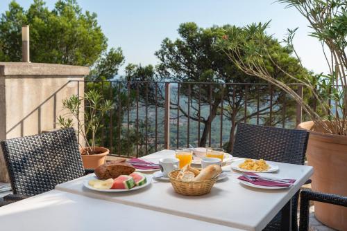 uma mesa branca com comida e bebidas em Petit Hotel Hostatgeria Sant Salvador em Felanitx