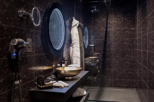 a bathroom with a bowl sink and a mirror at H Hotel & SPA - Adults Only in St Julian's