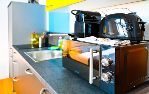 Backpacker Apartment Schönbrunn في فيينا: مطبخ مع آلة صنع القهوة على منضدة