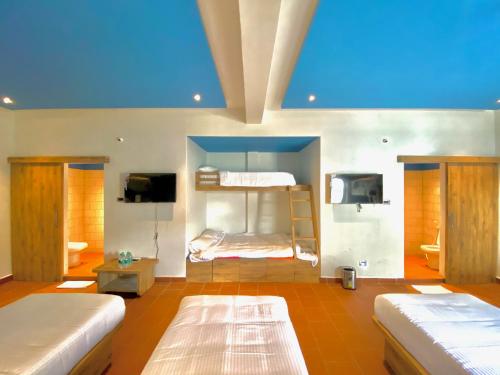 a room with two bunk beds and a blue ceiling at Riviera Beach Resort in Chīrāla