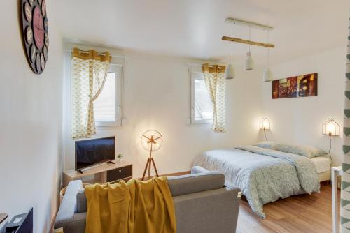 une chambre avec un lit, un canapé et une télévision dans l'établissement Chic studio avec parking au centre-ville, à Rouen