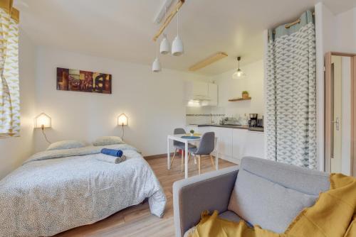 Cet appartement comprend une chambre avec un lit et un canapé ainsi qu'une cuisine. dans l'établissement Chic studio avec parking au centre-ville, à Rouen