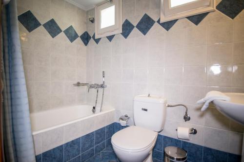 een badkamer met een toilet, een bad en een wastafel bij Sea Horse in Mithimna