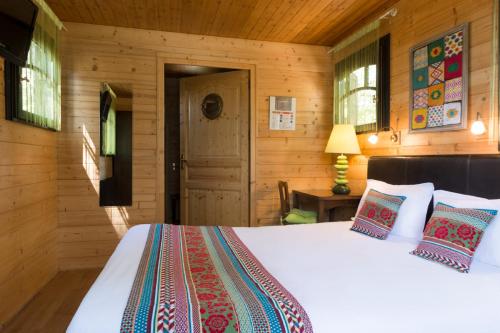 a bedroom with a bed in a wooden room at Auberge La Tomette, The Originals Relais in Vitrac