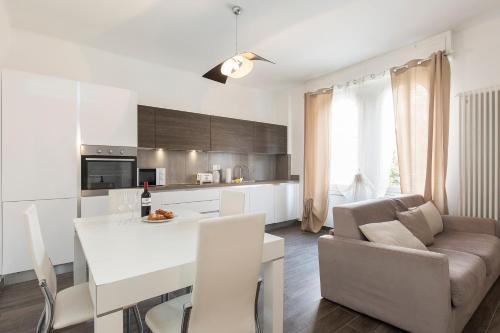a kitchen and living room with a white table and chairs at Maraini Apartments by Quokka 360 - strategic location near Lugano station in Lugano