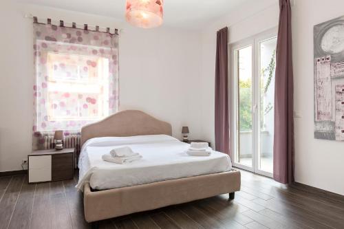 1 dormitorio con cama y ventana grande en Maraini Apartments by Quokka 360 - strategic location near Lugano station, en Lugano