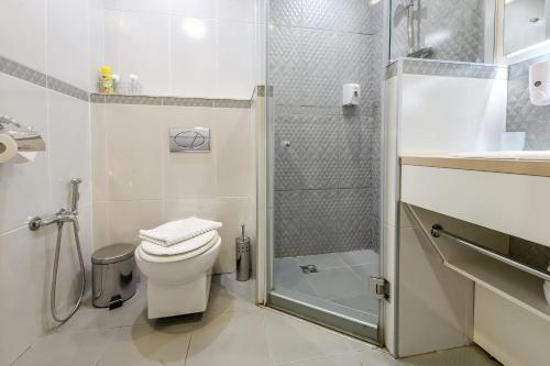a white bathroom with a toilet and a shower at Epigraph Hotel in Saint Petersburg
