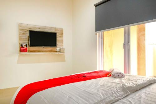 a bedroom with a bed with a tv on the wall at RedDoorz near Pasar Baru 3 in Jakarta