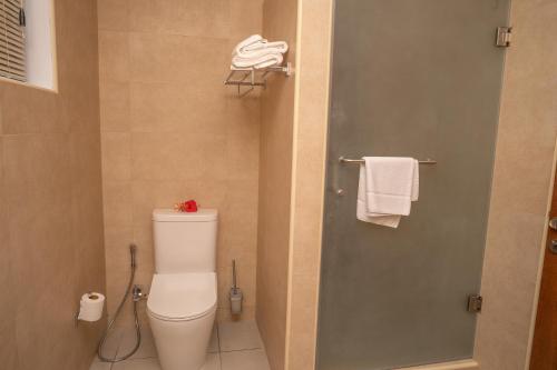 a bathroom with a toilet and a shower with towels at Kolibri Holiday Apartments in Victoria