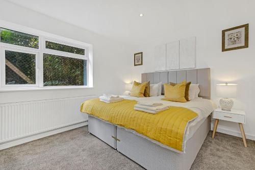 a bedroom with a large bed with a yellow blanket at St Martins 2 Bedroom Apartments in Ruislip By 360 Stays in Ruislip