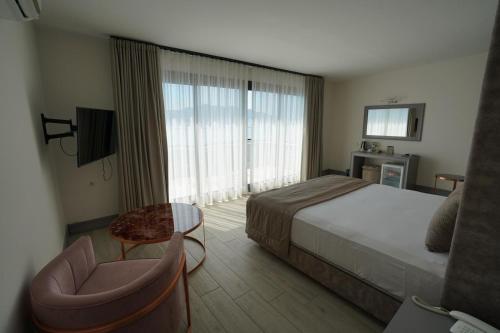 Habitación de hotel con cama y silla en Yunus Hotel en Marmaris