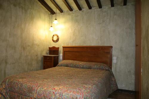 sypialnia z łóżkiem i zegarem na ścianie w obiekcie Cal Cisteller w mieście Gironella