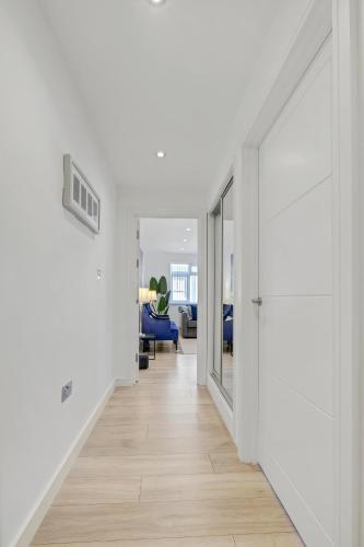 an empty hallway with white walls and wood floors at St Martins 2 Bedroom Apartments in Ruislip By 360 Stays in Ruislip
