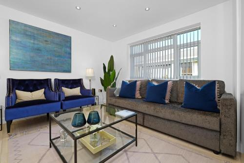 a living room with a couch and blue pillows at St Martins 2 Bedroom Apartments in Ruislip By 360 Stays in Ruislip
