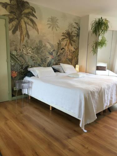 1 dormitorio con 1 cama blanca grande y un mural en Guesthouse Poppies, en Ostende