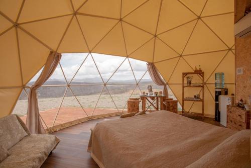 Cette grande tente comprend un lit et une grande fenêtre. dans l'établissement Glamping il Sole, à Civitella Marittima
