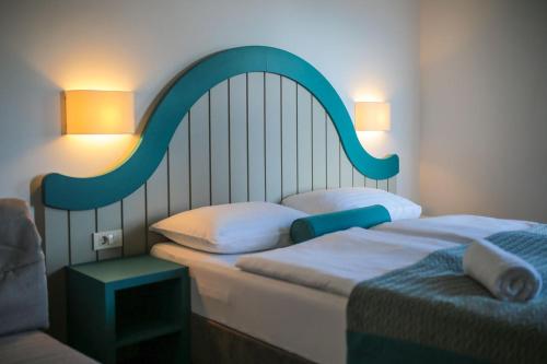 a bedroom with two beds with a large headboard at Hotel Ivando in Drvenik