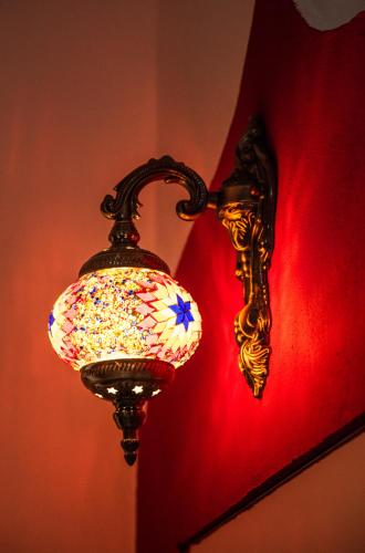 a light hanging on a wall with a red wall at CASE VACANZE I QUATTROVENTI in Lampedusa