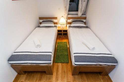 two beds in a small room with a green rug at Apartment Adria 3 in Malinska