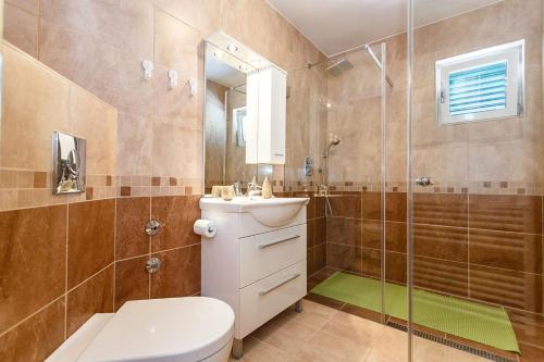 a bathroom with a toilet and a sink and a shower at Apartment Adria 3 in Malinska