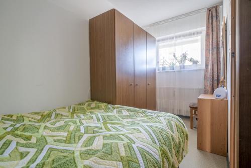 1 dormitorio con 1 cama y armario de madera en Private Apartment, en Hannover