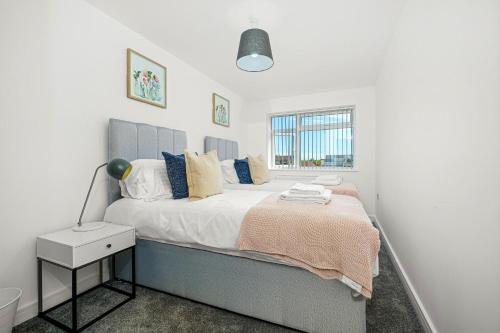 a white bedroom with a bed and a window at St Martins 2 Bedroom Apartments in Ruislip By 360 Stays in Ruislip