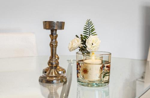 a lamp and a vase with a candle on a table at St Martins 2 Bedroom Apartments in Ruislip By 360 Stays in Ruislip