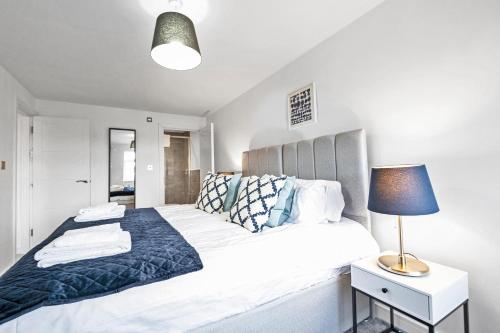 a bedroom with a large white bed with a lamp at St Martins 2 Bedroom Apartments in Ruislip By 360 Stays in Ruislip