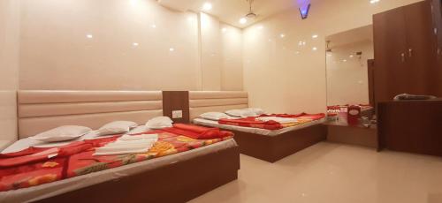 two beds in a room with a mirror at Ashiyana Inn Hotel in Ajmer