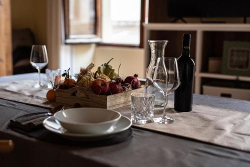 a table with two wine glasses and a basket of fruit at la casetta in Sassari