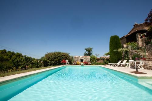 une piscine avec de l'eau bleue devant une maison dans l'établissement Chez Suzanne, à Bonnieux