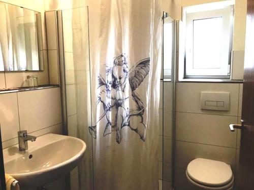 ein Bad mit einem Duschvorhang und einem Waschbecken in der Unterkunft Gästehaus Hirlinger in Burladingen