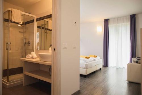 a bathroom with a bed and a sink and a mirror at Maso Agritur Santa Lucia in Dro