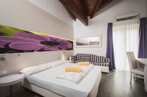 a bedroom with a large purple flower painting on the wall at Maso Agritur Santa Lucia in Dro