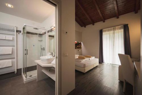 a bathroom with a sink and a shower and a bed at Maso Agritur Santa Lucia in Dro