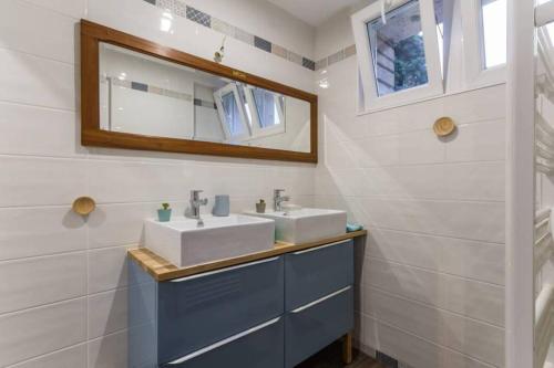 une salle de bain avec deux lavabos et un miroir dans l'établissement La Maison Bleue au coeur des Plages du Débarquement, à Ver-sur-Mer