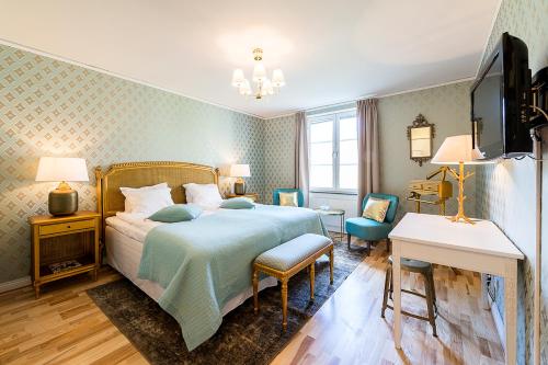 Krusenberg的住宿－庫瑞博歌酒店，一间卧室配有一张床、一张书桌和一台电视