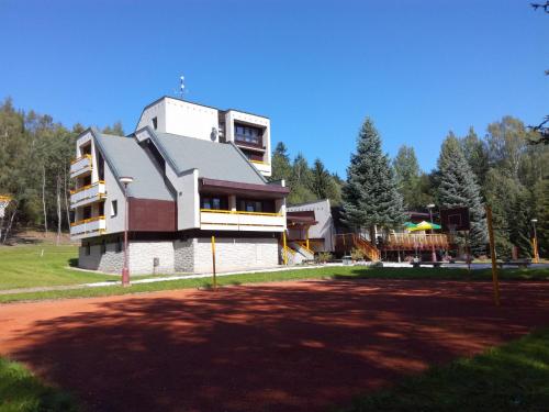 a large building in a park next to a field at Hotel ČESKÁ FARMA in Dolni Dvur