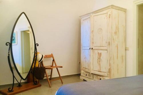 a bedroom with a mirror and a wooden dresser at Stefani Cave House Santorini in Firostefani