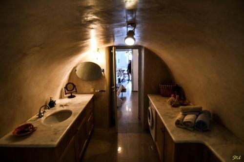 a bathroom with a sink and a hallway at Stefani Cave House Santorini in Firostefani