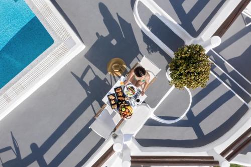 an overhead view of a person sitting at a table with a skateboard at Caldera Premium Villas in Oia