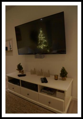 a white entertainment center with a flat screen tv on a wall at Nordstern in Büdelsdorf