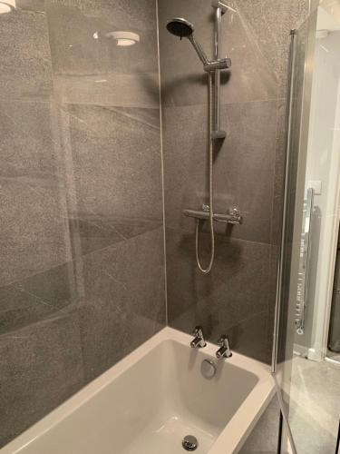 een badkamer met een douche en een bad met een wastafel bij Saint Johns Rest in Biggleswade