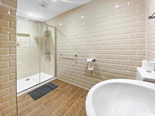 y baño con aseo blanco y ducha. en Church suite, Stow-on-the-Wold, Sleeps 4, town location, en Stow on the Wold