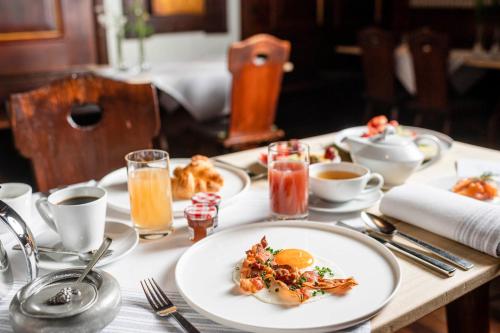 a table with a white plate of food on it at Romantik Hotel Zur Schwane in Volkach
