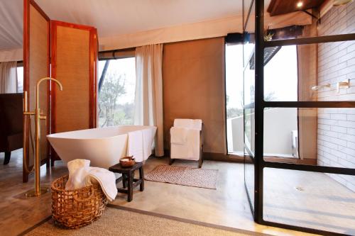 a bathroom with a tub and a large window at Thabamati Luxury Tented Camp in Timbavati Game Reserve
