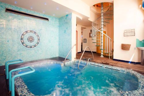 Bellavista Lakefront Hotel & Apartments في ريفا ديل غاردا: حوض جاكوزي في غرفة مع بلاط أزرق